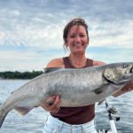 Angler holding trophy King Salmon on a Traverse City Fishing charter with Storm Hawk