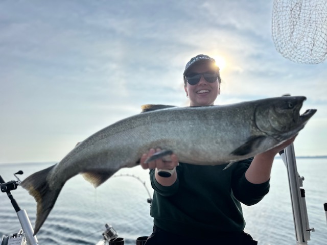 Woman holding a large salmon caught during a Traverse City fishing charter on West Grand Traverse Bay