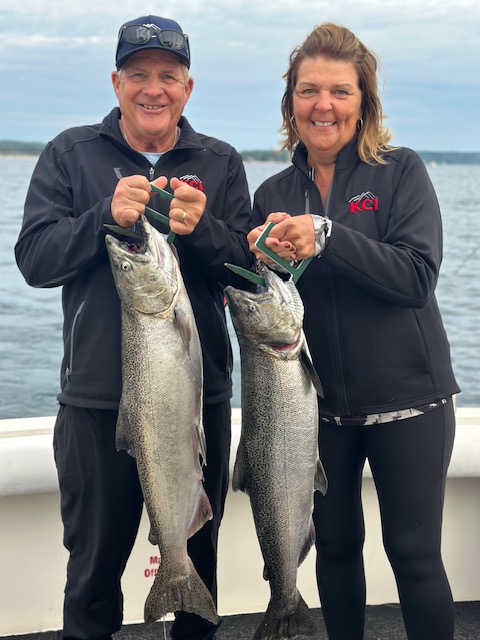 couple holding two Lake Michigan king salmon during a Traverse City fishing charter on West Grand Traverse Bay.